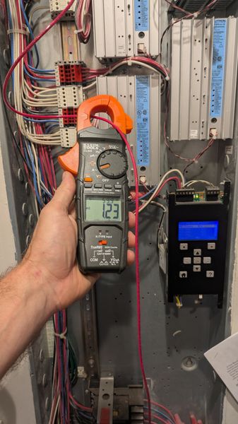 Clamp meter measuring voltage at a lighting control panel