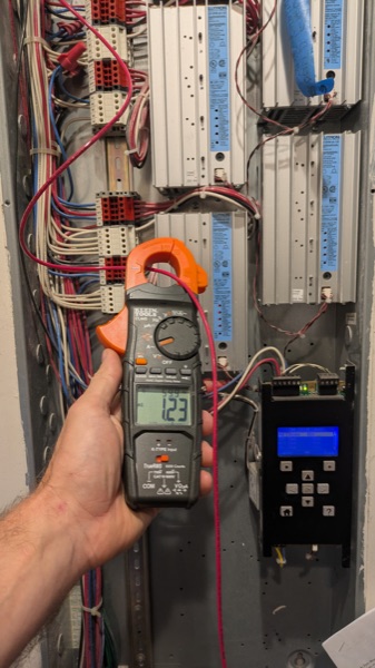 Clamp meter reading current inside a commercial control panel