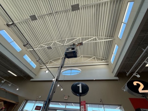 Boom lift positioned to service high-bay lighting in a commercial retail store