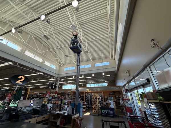 Interior of a retail store during overhead commercial lighting work from a lift