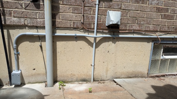Neat exterior conduit run along a home's foundation