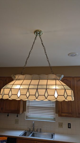Stained glass pendant hung over a kitchen sink