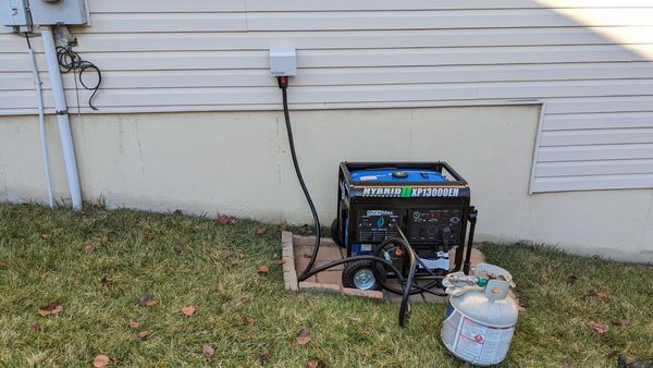 Dual-fuel portable generator connected to a home through an exterior power inlet