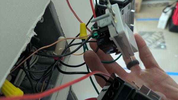 Smart dimmer switch being wired into a wall box