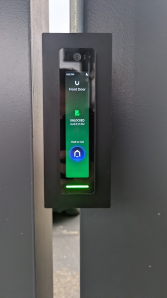 Smart door access reader showing an unlocked front door