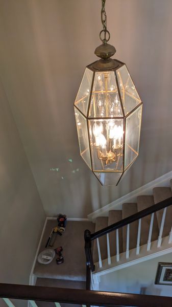 Beveled-glass lantern pendant installed over a residential staircase