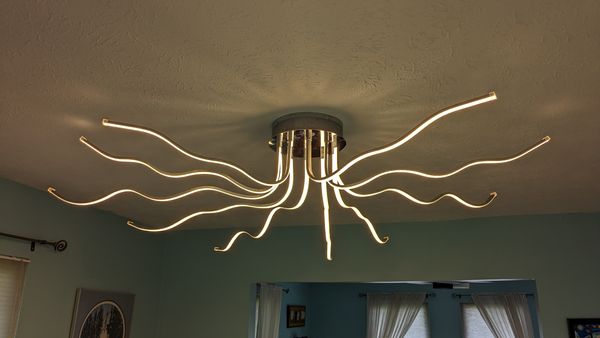 Modern wavy LED ceiling light fixture installed in a living room