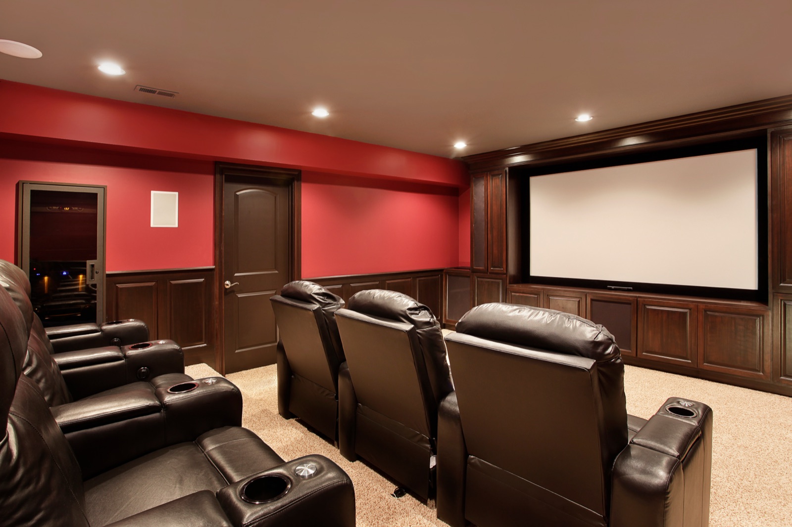 Home theater room with projection screen and tiered seating wired by Benrishi Electrical